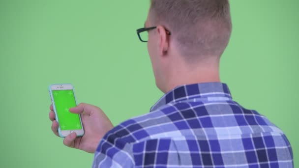 Крупним планом вид ззаду молодий хіпстер використовує телефон — стокове відео