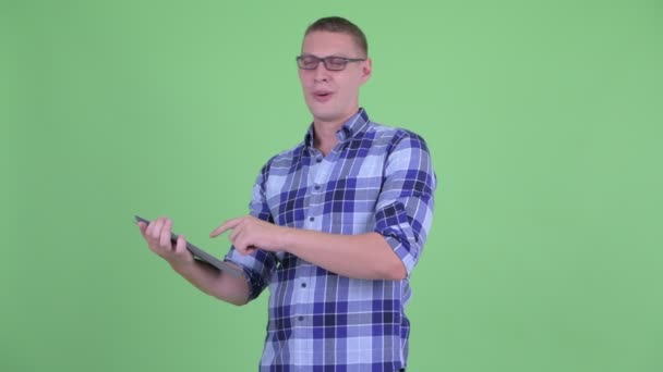Boldog fiatal csípő ember beszél használata közben a digitális tabletta — Stock videók