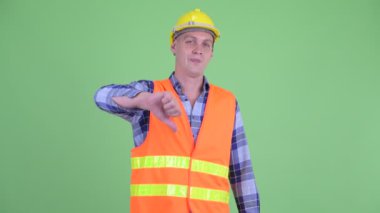Üzgün genç adam inşaat işçisi aşağı başparmak veren
