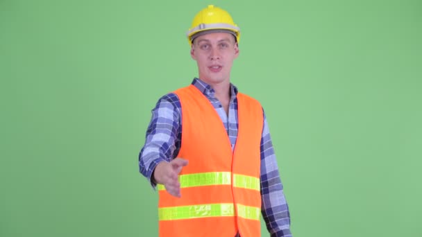 Boldog fiatalember építőmunkás giving kézfogás — Stock videók