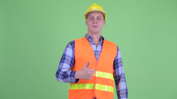 Feliz joven trabajador de la construcción dando pulgares hacia arriba — Vídeos de Stock