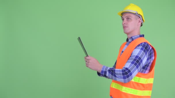Profilbild eines glücklichen jungen Mannes Bauarbeiter liest auf Klemmbrett — Stockvideo