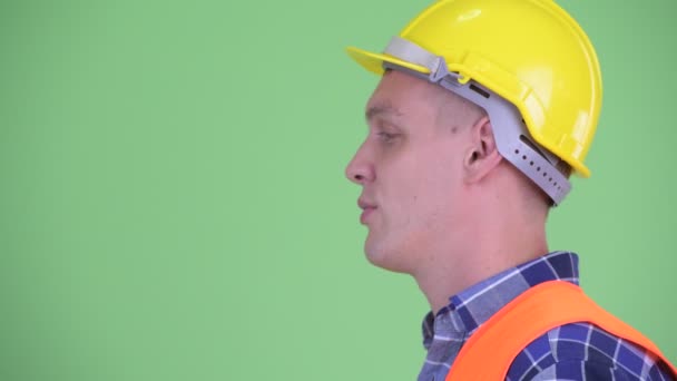 Profilvy av lycklig ung man byggnadsarbetare pratar — Stockvideo