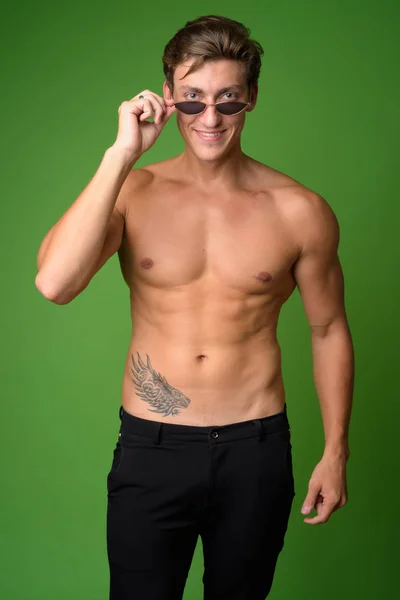 Portrait of young handsome shirtless man wearing sunglasses — Stock Photo, Image