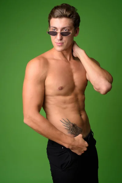 Porträt eines jungen gutaussehenden Mannes ohne Hemd und Sonnenbrille — Stockfoto