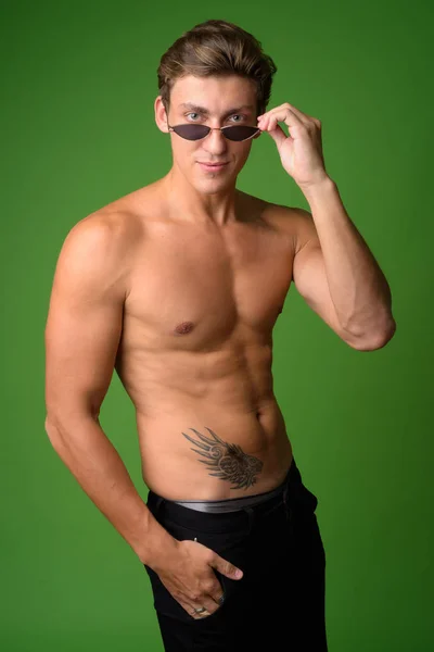 Ritratto di giovane bell'uomo senza camicia che indossa occhiali da sole — Foto Stock