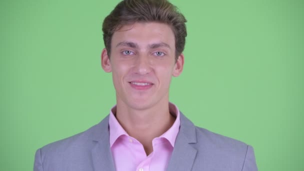 Gezicht van gelukkige jonge zakenman glimlachend — Stockvideo