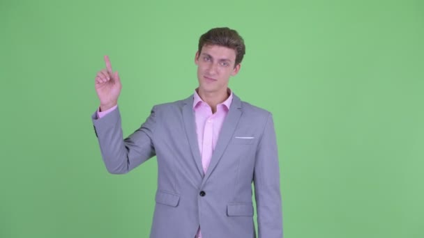 Happy young businessman pointing up — Stock Video