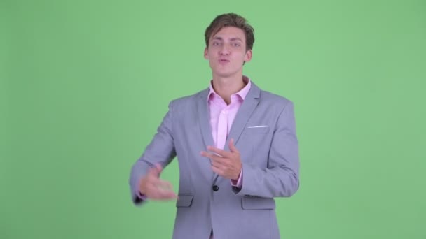 Šťastný mladý obchodník vysvětluje něco — Stock video