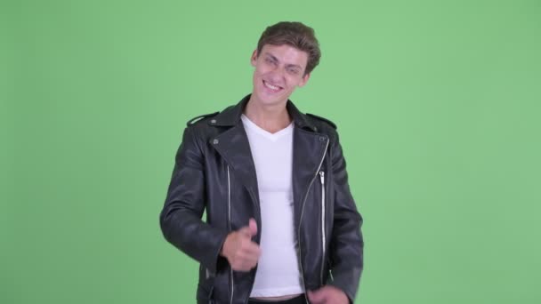 Happy young rebellious man giving thumbs up and looking excited — Stock Video