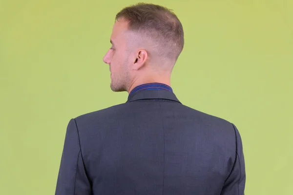 Closeup rear view of businessman in suit looking over shoulder — Stock Photo, Image