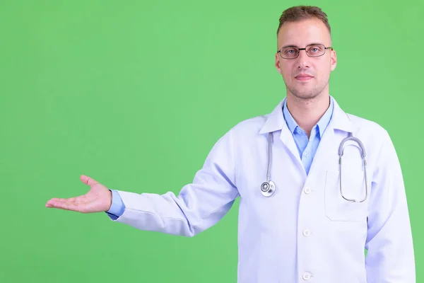 Pohledný doktor s brýlemi, který ukazuje něco — Stock fotografie