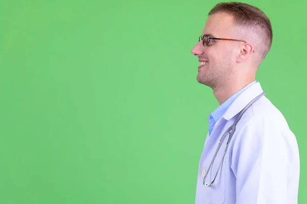 Visão de perfil de close-up de homem bonito feliz médico com óculos sorrindo — Fotografia de Stock