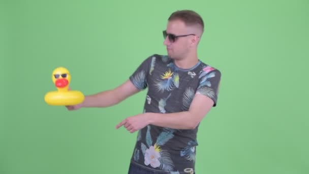 Hombre guapo feliz con gafas de sol bailando con pato inflable — Vídeos de Stock