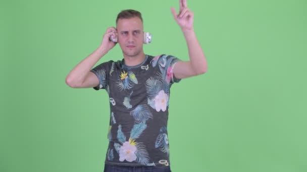 Feliz hombre guapo como dj con auriculares — Vídeo de stock