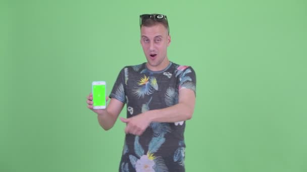 Szczęśliwy przystojny człowiek z okulary pokazując telefon i dający kciuki w górę — Wideo stockowe
