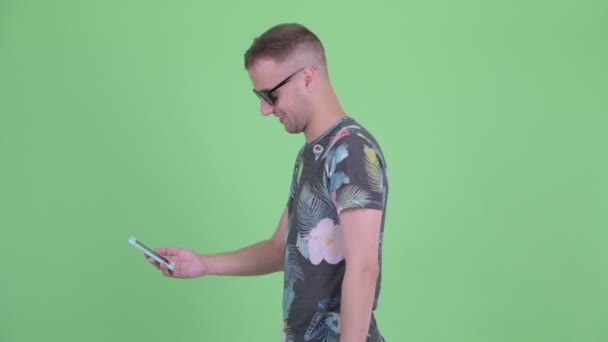 Glücklicher gutaussehender Mann mit Sonnenbrille, dem das Handy weggenommen wird — Stockvideo