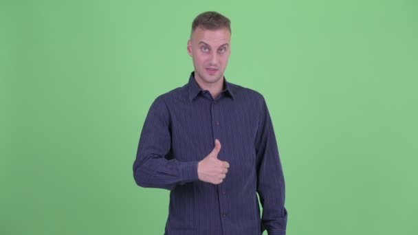 Счастливый привлекательный бизнесмен, показывающий большие пальцы — стоковое видео