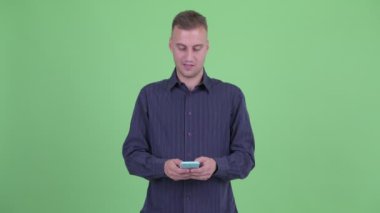 Telefon kullanırken düşünerek mutlu yakışıklı işadamı
