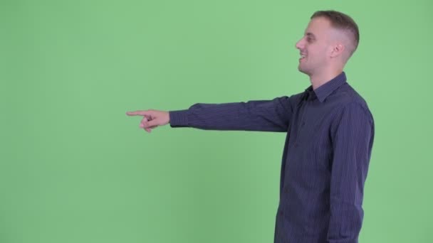 Vue du profil de heureux bel homme d'affaires pointant du doigt — Video