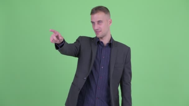 Takım elbiseli mutlu yakışıklı işadamı işaret parmağı — Stok video