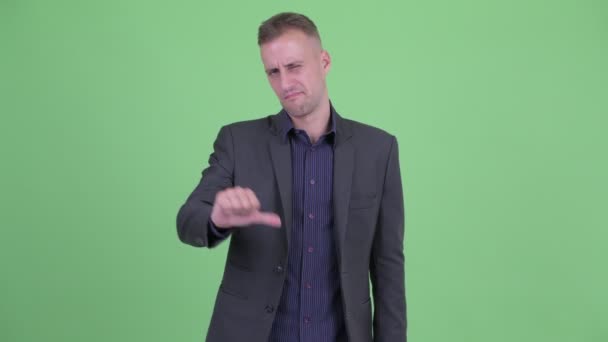 Stressed businessman in suit giving thumbs down — Stock Video