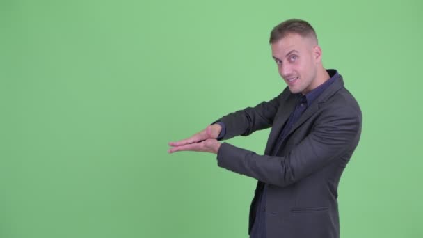 Glücklicher gutaussehender Geschäftsmann im Anzug schnippt mit den Fingern und zeigt etwas — Stockvideo