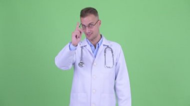 Mutlu yakışıklı adam doktor kamera işaret