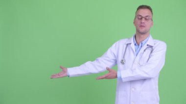 Mutlu yakışıklı adam doktor bir şey gösterirken konuşuyor