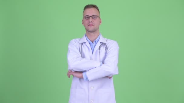 Ευτυχισμένος όμορφος άντρας γιατρός χαμογελαστός με τα χέρια σταυρωτά — Αρχείο Βίντεο