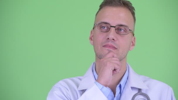 幸せなハンサムな男医者の顔思考と見上げ — ストック動画