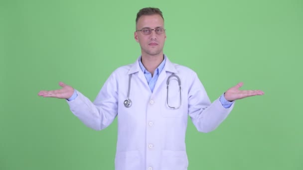 Šťastný fešák doktor srovnávání něčeho — Stock video