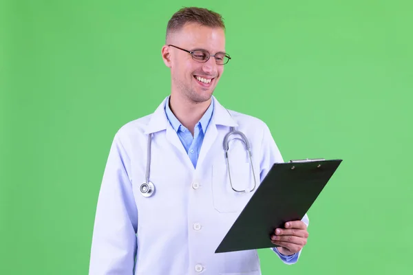 Médico homem bonito feliz com óculos lendo na área de transferência — Fotografia de Stock