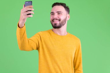 Mutlu genç yakışıklı sakallı adam selfie çekerken
