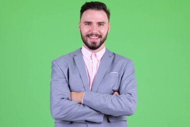 Mutlu genç yakışıklı sakallı işadamı kolları çapraz gülümseyerek
