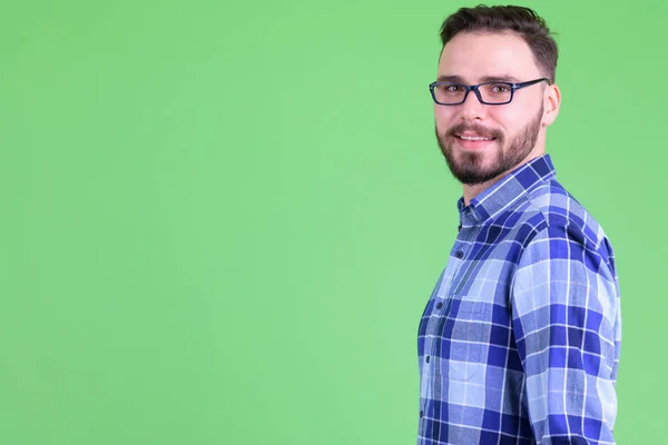 Vista de perfil de joven y feliz barbudo hipster hombre mirando a la cámara —  Fotos de Stock