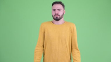 Şaşkın genç yakışıklı sakallı adam omuz silkme