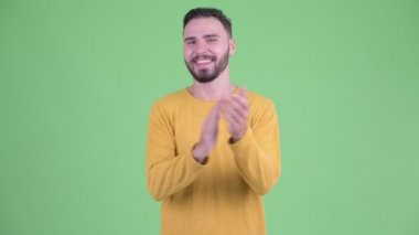 Mutlu genç yakışıklı sakallı adam alkışlayarak el