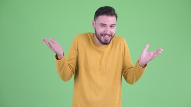 Happy young handsome bearded man shrugging shoulders and looking guilty — Stock Video