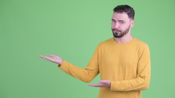 Stressed young bearded man showing something — Stock Video