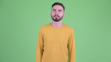Stresli genç sakallı adam sıkılmış ve yorgun görünüyor.