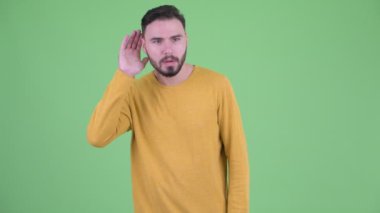 Mutlu genç yakışıklı sakallı adam dinleme ve iyi haber alma