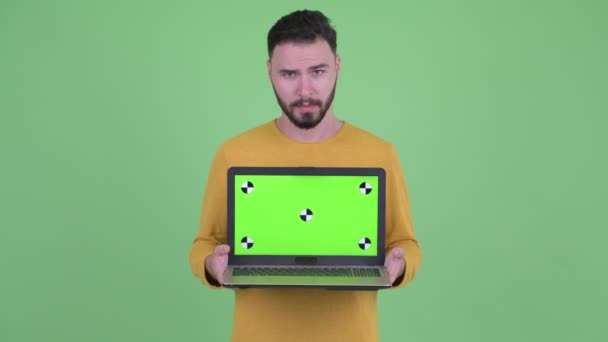 Hangsúlyozta fiatal szakállas férfi bemutató laptop és kapok rossz hír — Stock videók