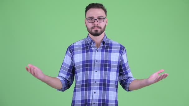 Happy young bearded hipster man comparing something — Stock Video