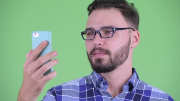 Visage de heureux jeune homme barbu hipster en utilisant le téléphone — Video