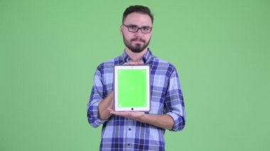 Stresli genç sakallı hipster adam dijital tablet gösteren