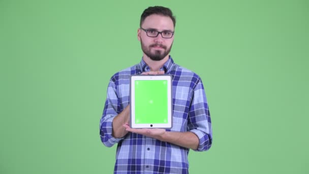 Stressed young bearded hipster man showing digital tablet — Stock Video