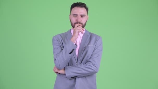 Stressed young bearded businessman thinking and looking down — Stock Video