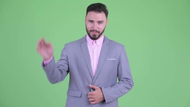 Счастливый молодой красивый бородатый бизнесмен машет рукой — стоковое видео