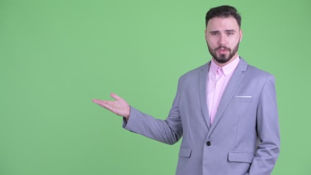 Happy young bearded businessman presenting something — Stock Video